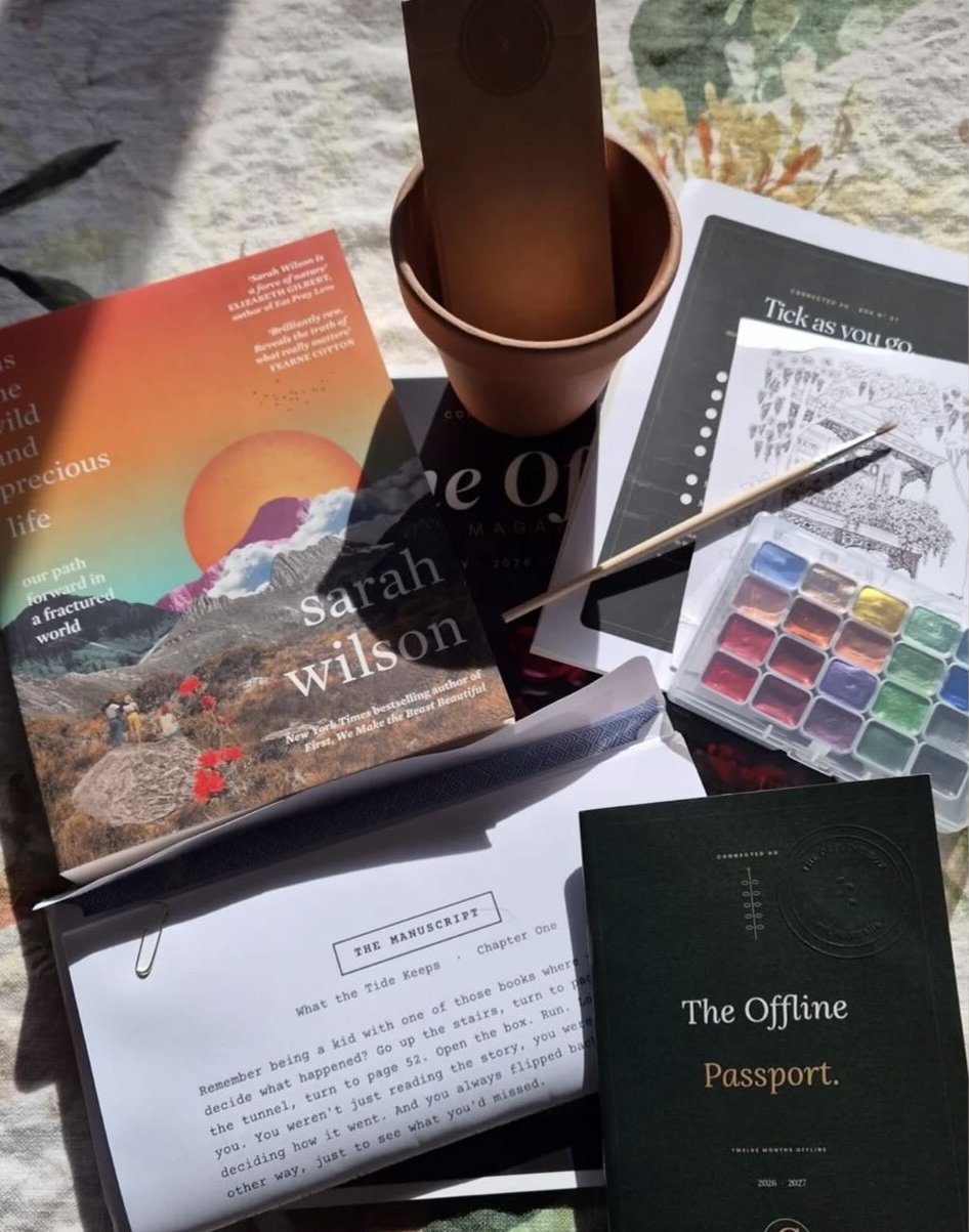 A member's Offline Box laid out at home: a book, watercolours, a pot to plant and the Passport