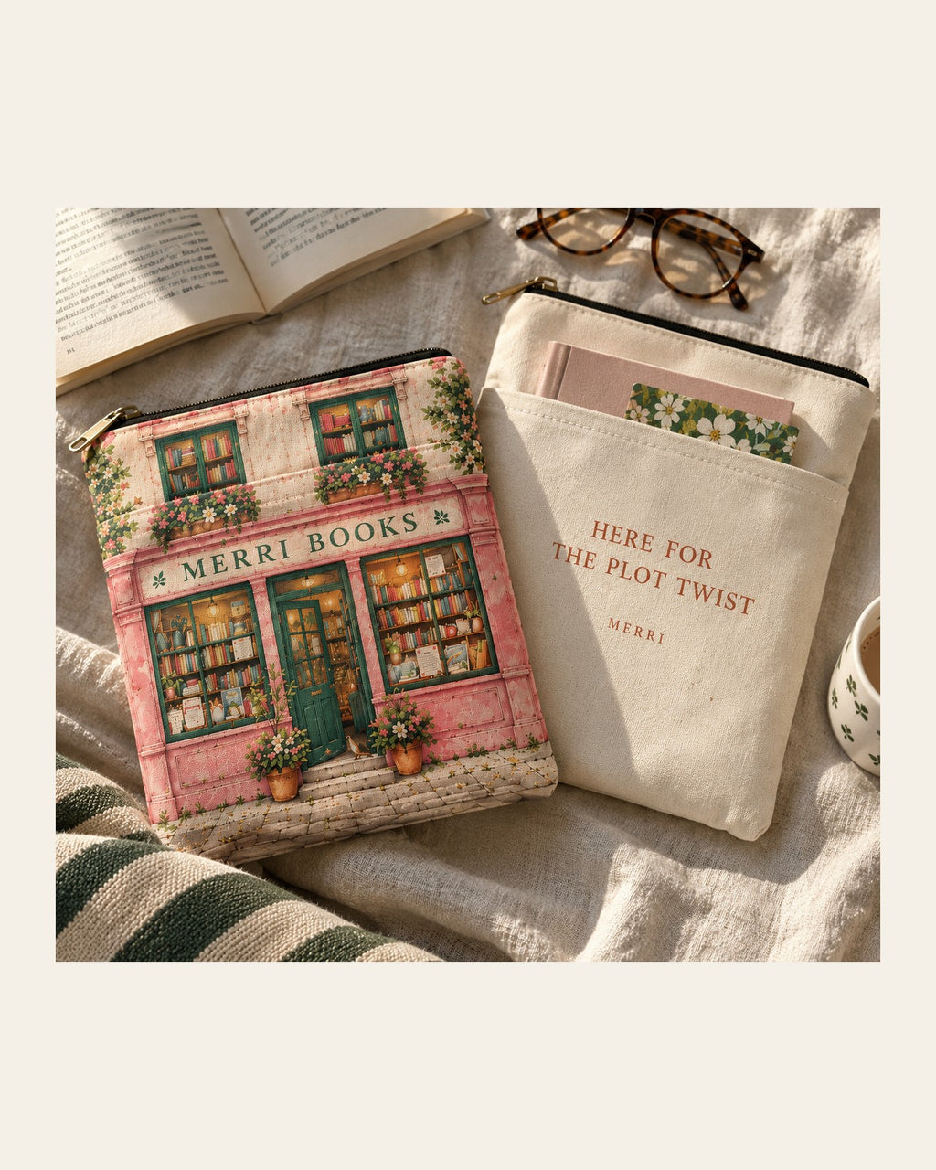 Two MERRI padded book pouches, the pink Bookshop Edition and the cream Here for the Plot Twist, on linen