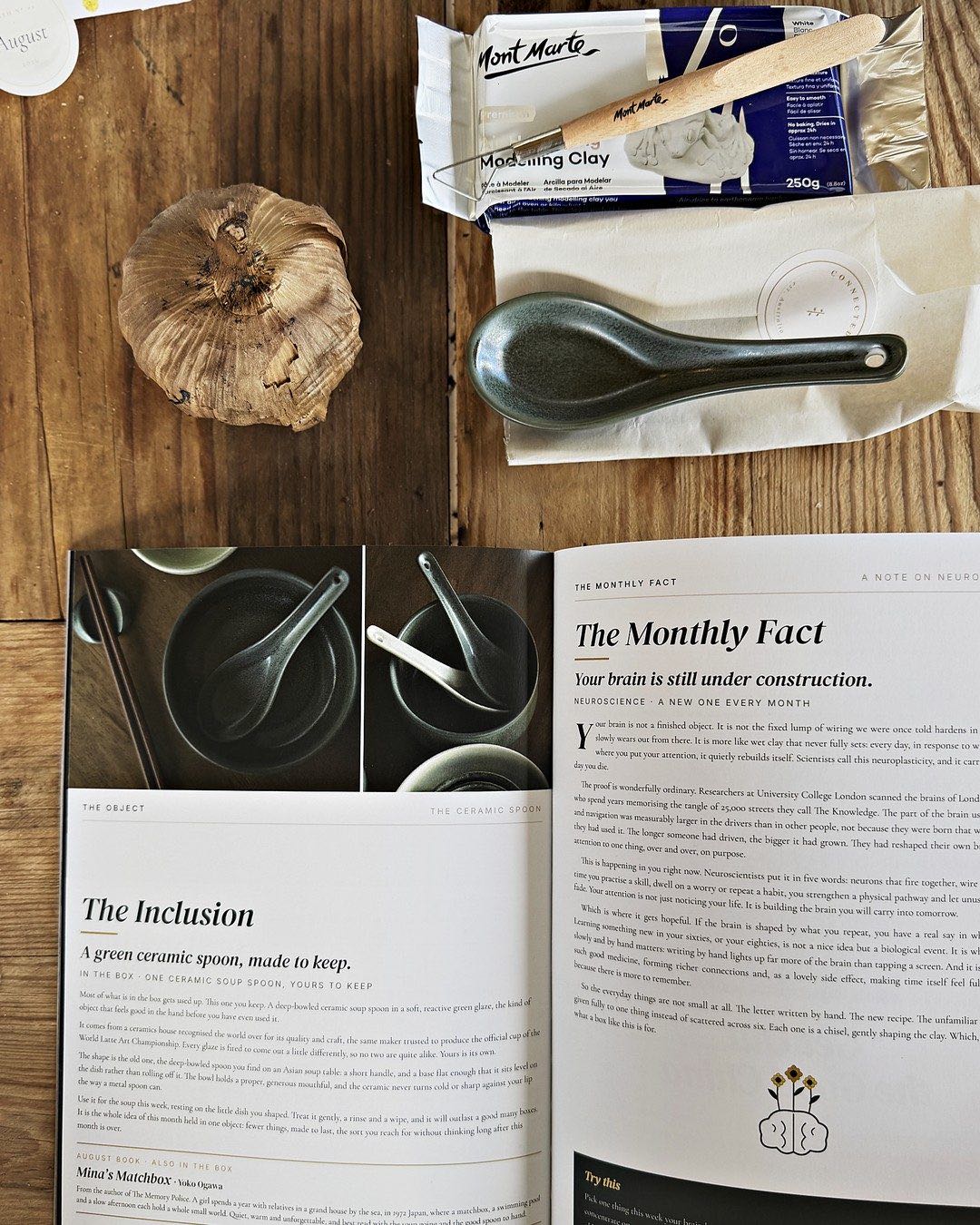 The clay, the ceramic spoon and black garlic, with the magazine